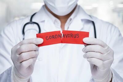 Arzt mit Mund-Nasen-Schutz mit Zettel in der Hand auf dem Coronavirus steht